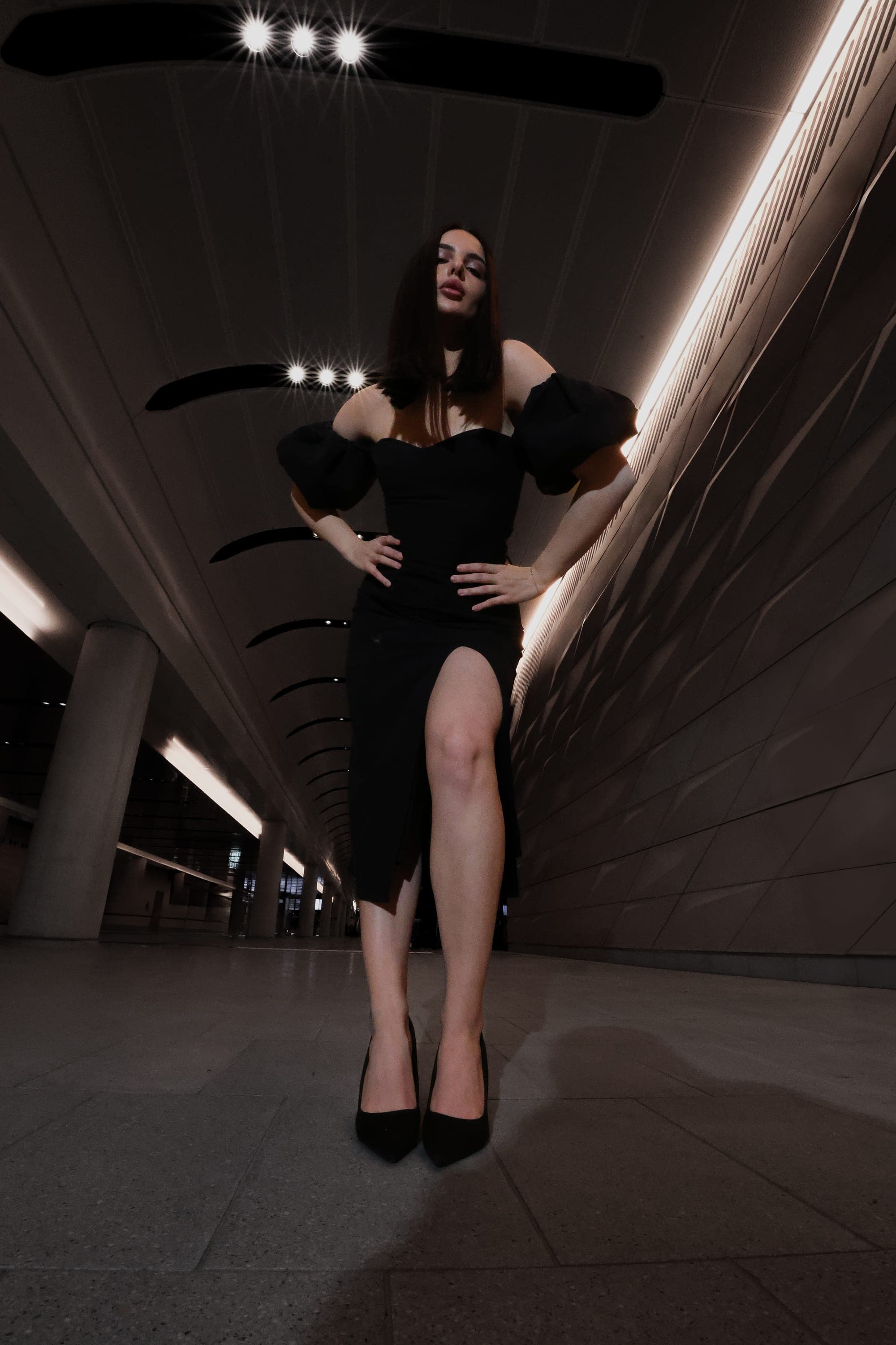 Model in a puff-sleeve black gown in an illuminated station tunnel, Sydney street fashion